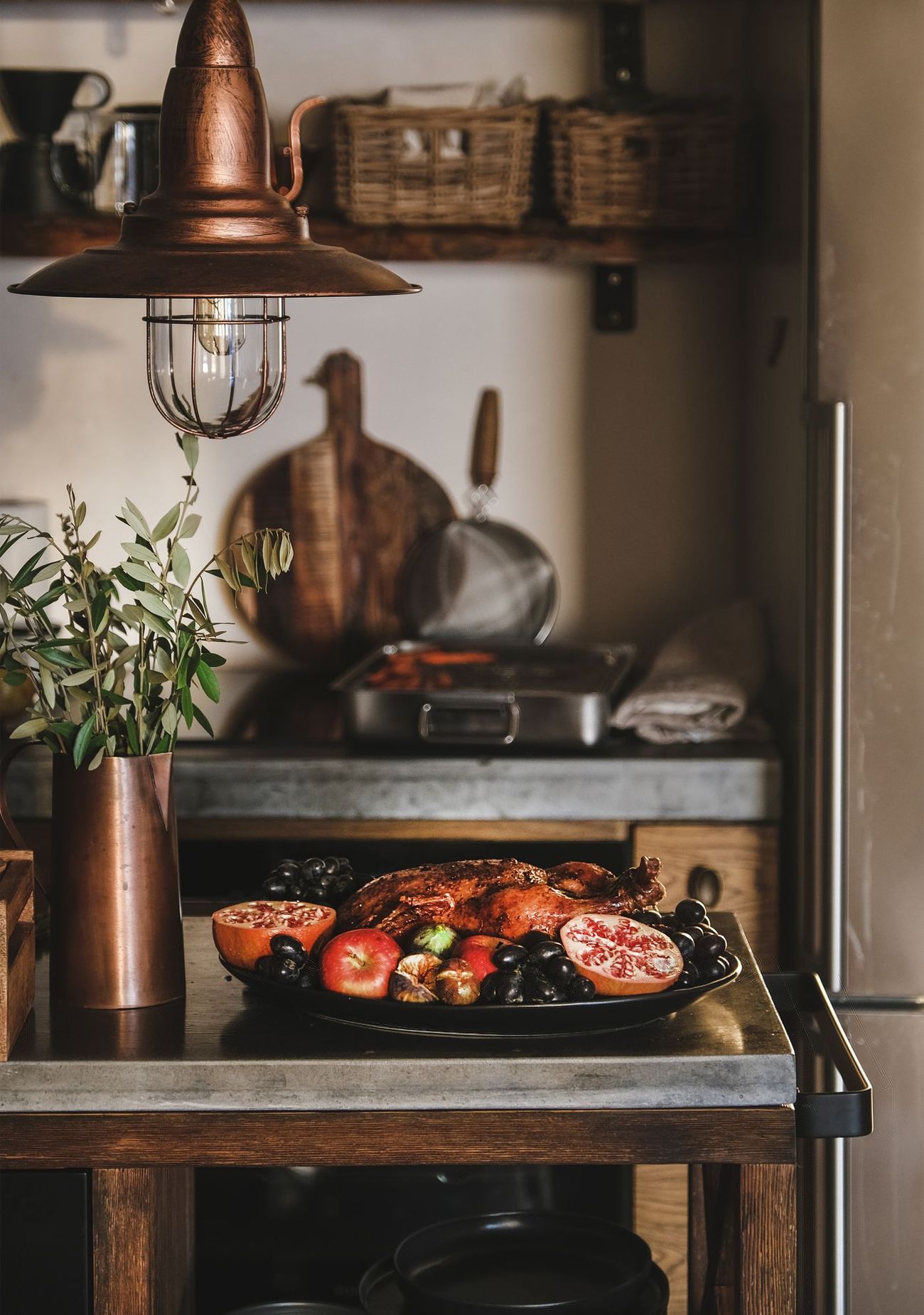 Warme Küche mit Kupferlampe, Regalen und angerichtetem Essen